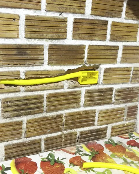 Conduíte amarelo passando por dentro da parede até a caixa da tomada